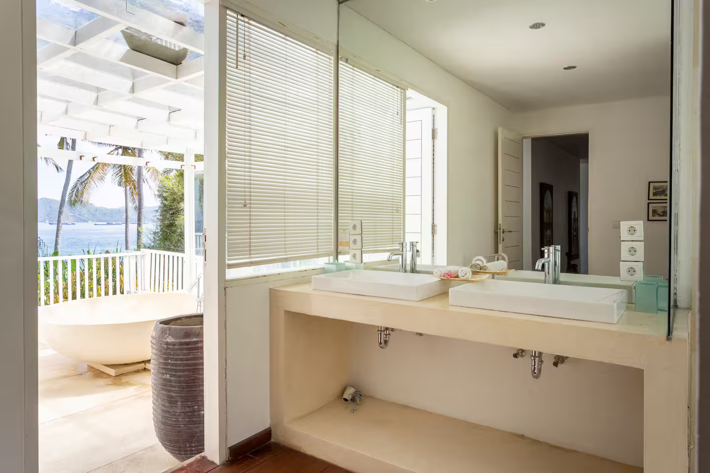 Bright bathroom with a large mirror and garden views
