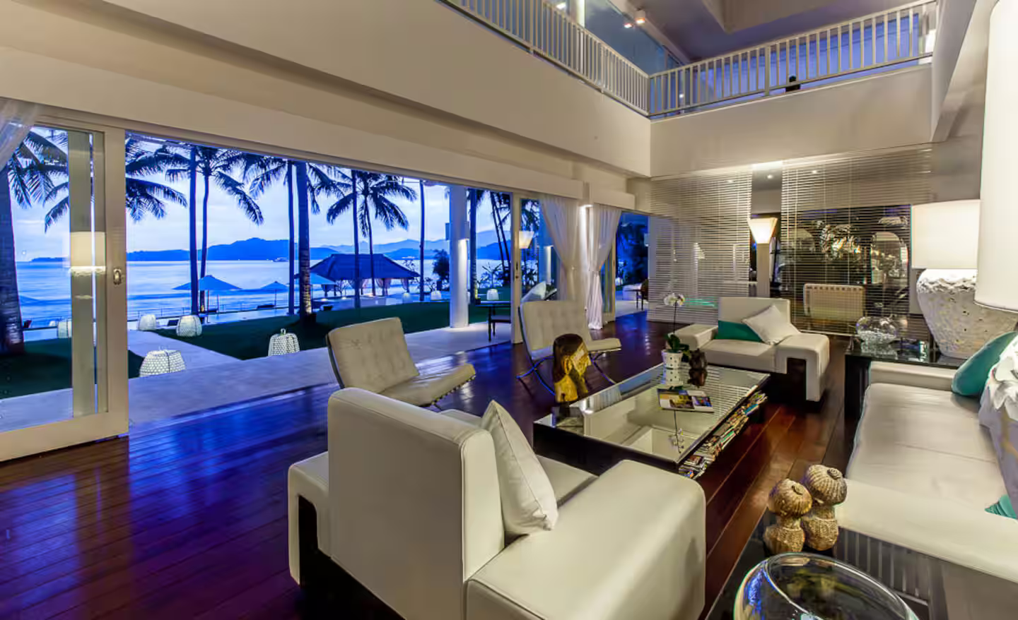Living room illuminated at dusk with ocean views