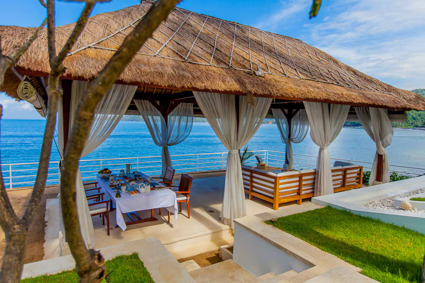 Open-air beachfront pavilion beside the lawn