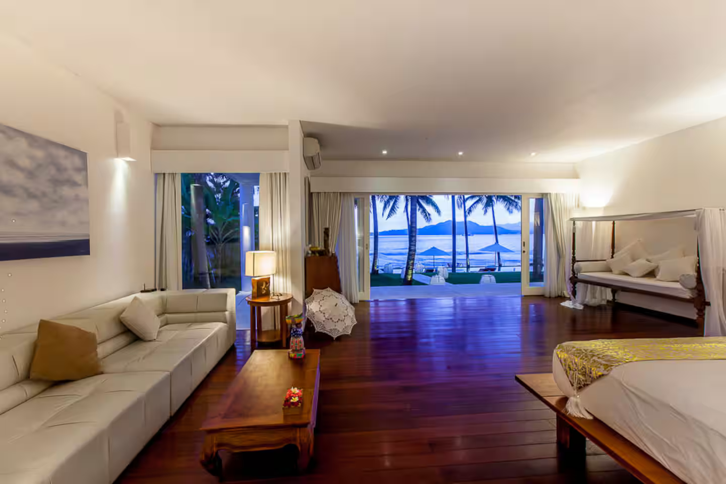 Bedroom with a view across the pool at dusk