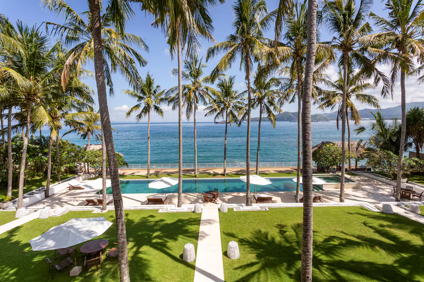 Palm-lined lawn overlooking the beach and sea