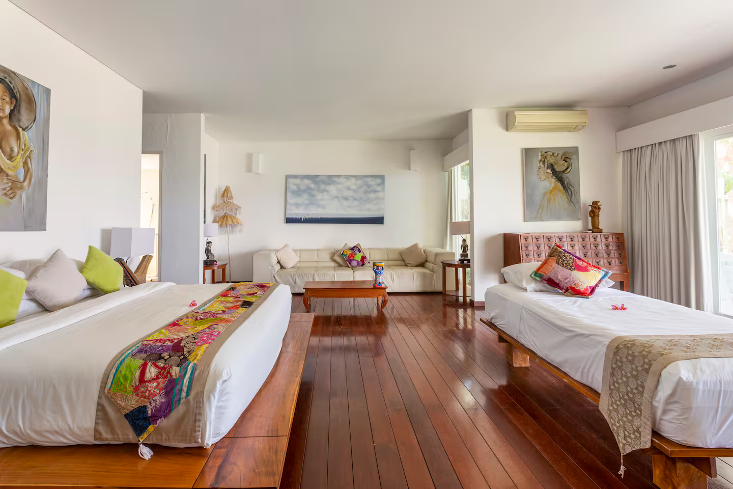 Twin bedroom with colourful cushions and wooden floors