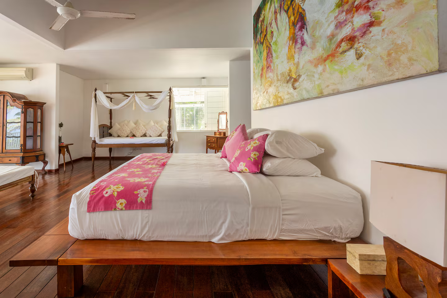 Bedroom with colourful cushions and garden views